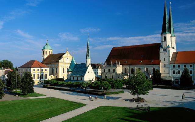 Der Altöttinger Kapellplatz mit einer kleine Kapelle sowie einer großen Wallfahrtskirche im Hintergrund