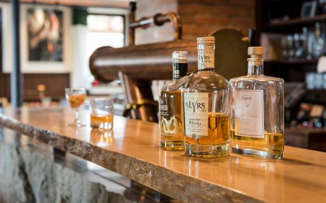 Auf dem Tresen der Barothek im Gasthof Raspl stehen mehrere Flaschen mit Whiskey, im Hintergrund ist die Zapfanlage zu sehen