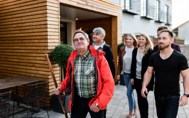 Eine Gruppe verlässt das Hotel Traumschmiede und bricht zu einer Wanderung auf